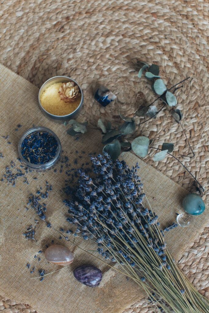 Relaxing still life with lavender, stones, and aromatherapy elements on a woven mat.