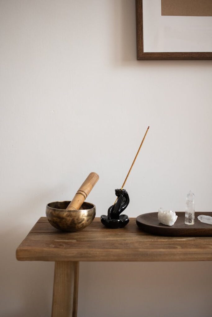 Minimalist interior with mortar, incense, and crystals on a wooden table.